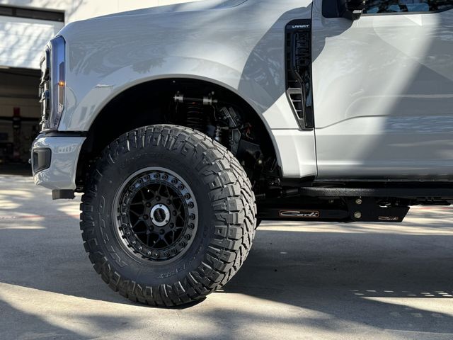 White lifted pickup truck with large off-road tires parked in sunlight