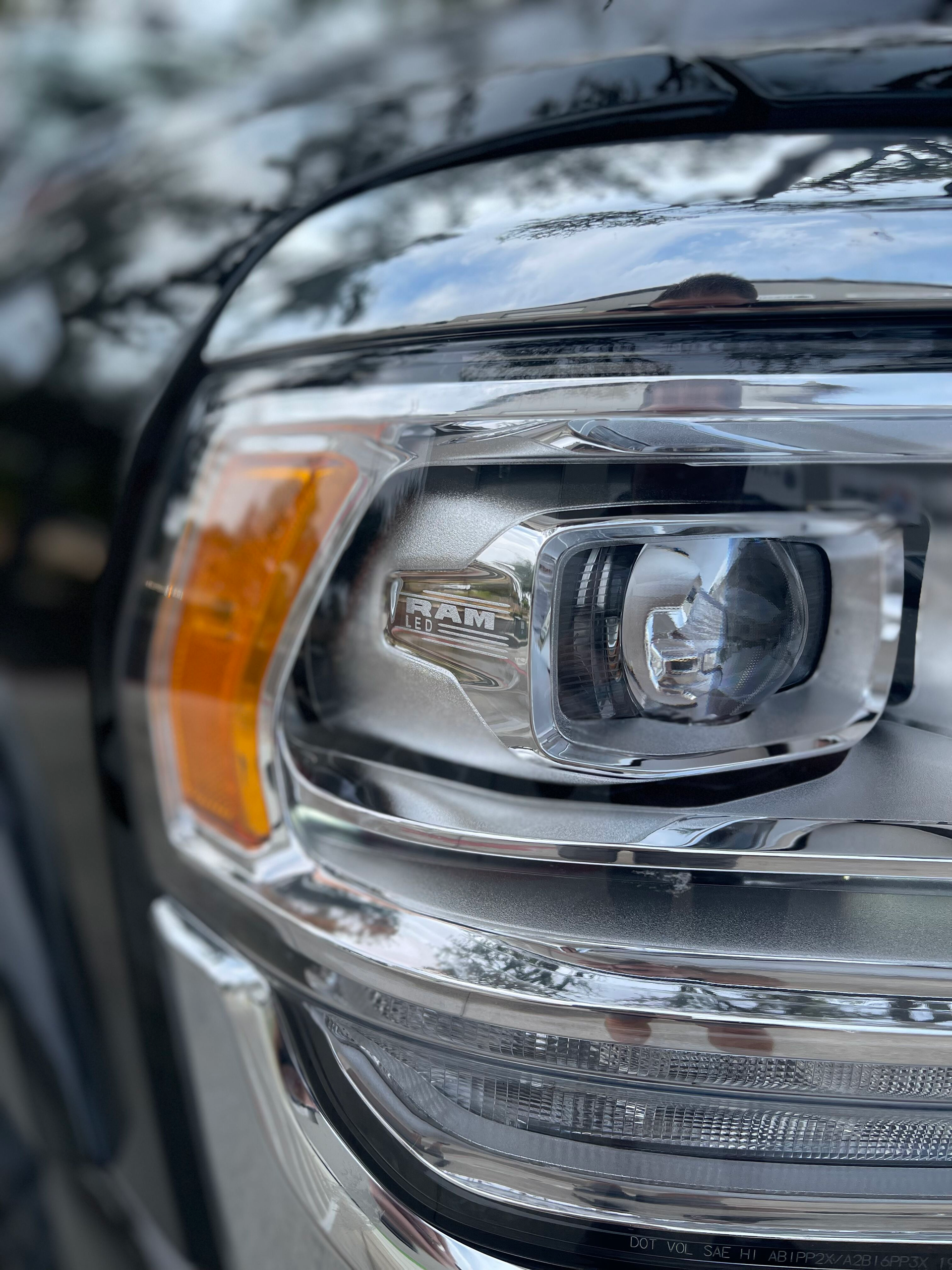 Close-up of a chrome car headlight with an amber turn signal