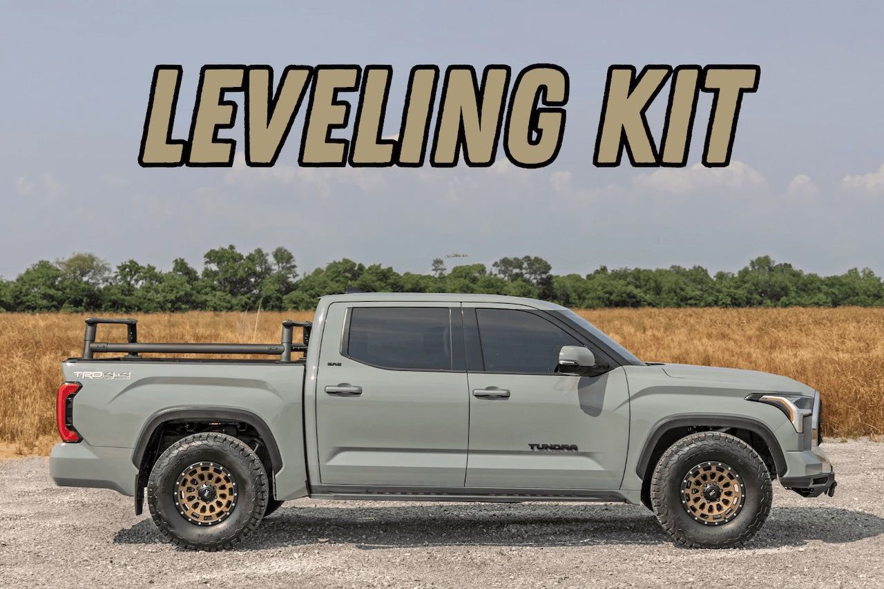 Gray lifted pickup truck in a gravel lot with bold “LEVELING KIT” text above it