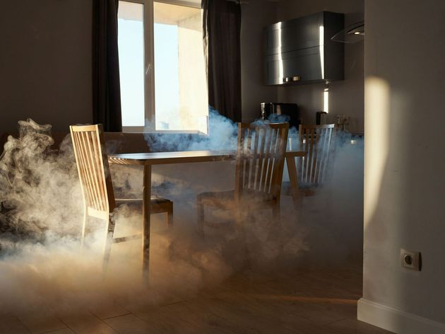 Smoke is coming out of a room with a table and chairs.
