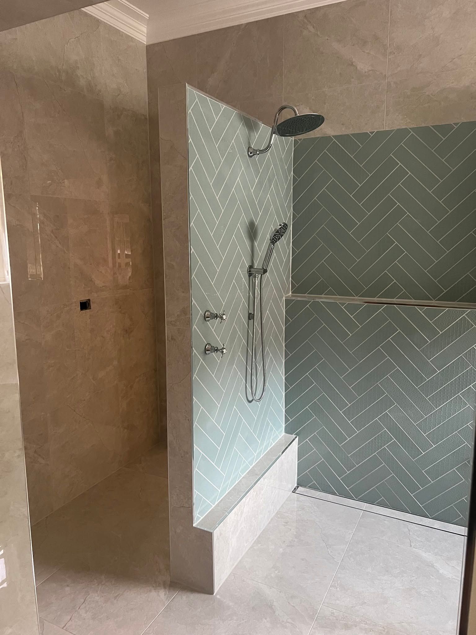 Bathroom Shower With Glass Enclosure, Beige Walls, Gray Patterned Tile, And White Shower Base by McGrath Builders & Associates in Lavington NSW.