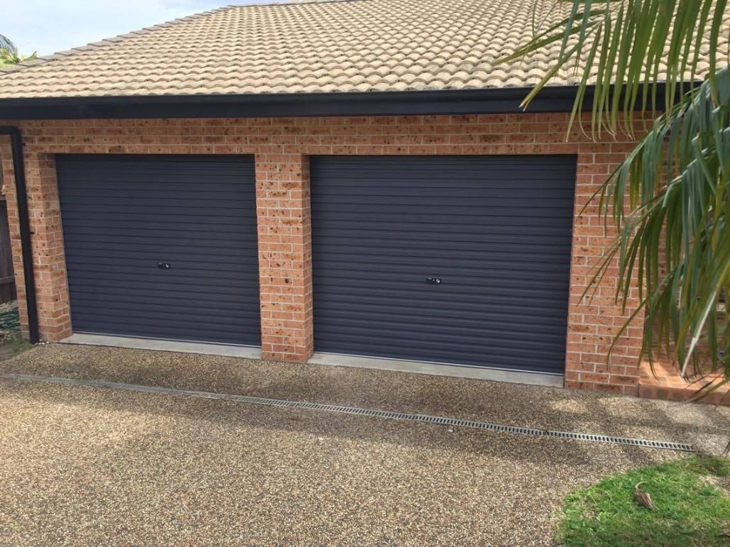 A White House With a White Garage Door and a Driveway — P & D Garage Doors in Old Bar, NSW