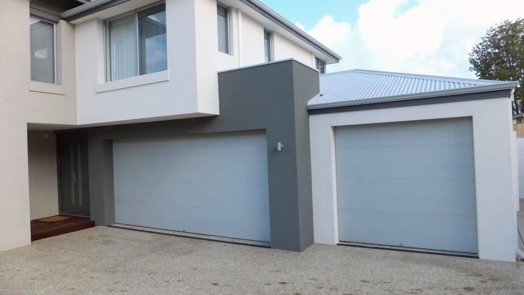 A white house with a gray garage door — P & D Garage Doors in Pacific Palms, NSW