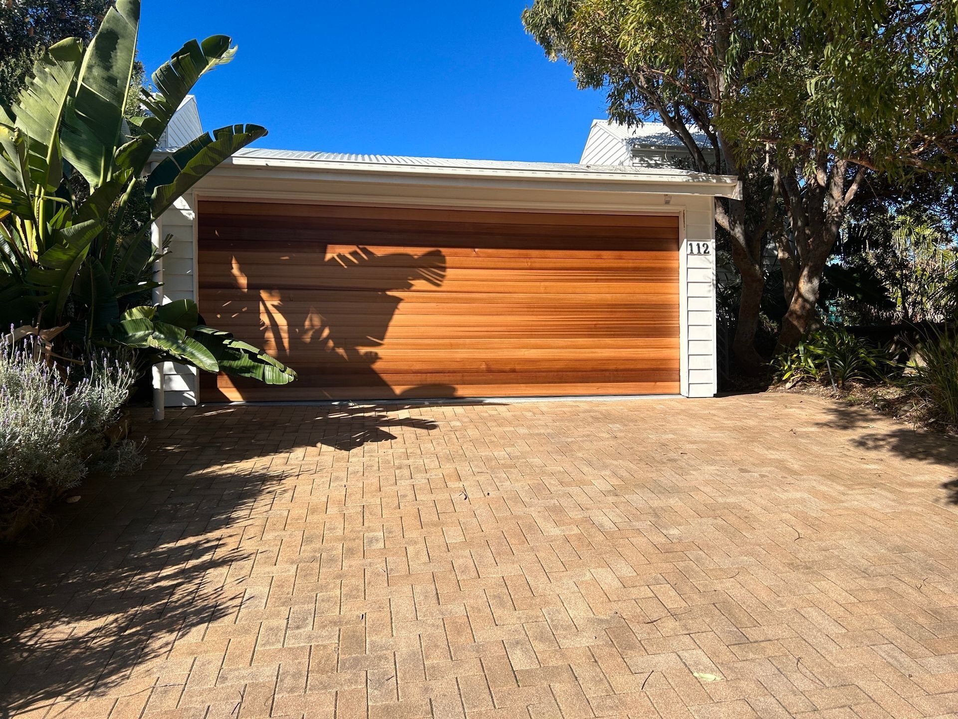 Timber Clad Garage Door On Brick Driveway Outdoors