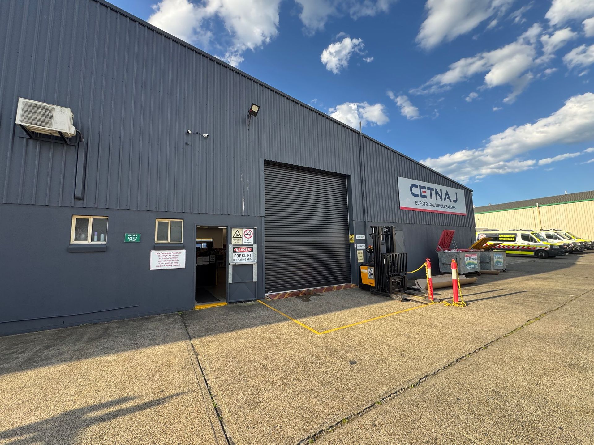 Industrial Warehouse Exterior With Blue Metal Siding — P & D Garage Doors in Taree, NSW
