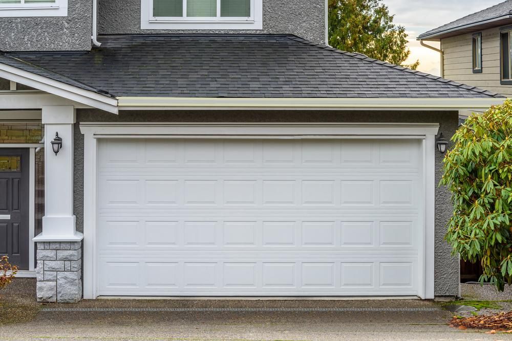 A Large House With a White Garage Door and a Black Roof — P & D Garage Doors in Gloucester, NSW