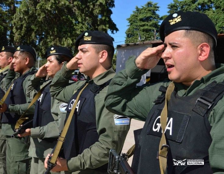 Policías argentinos con uniformes verde oliva, saludando, con 