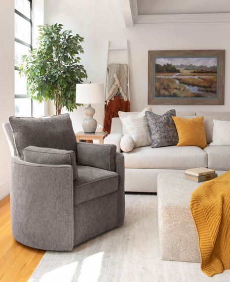 A living room with a couch , chair and ottoman