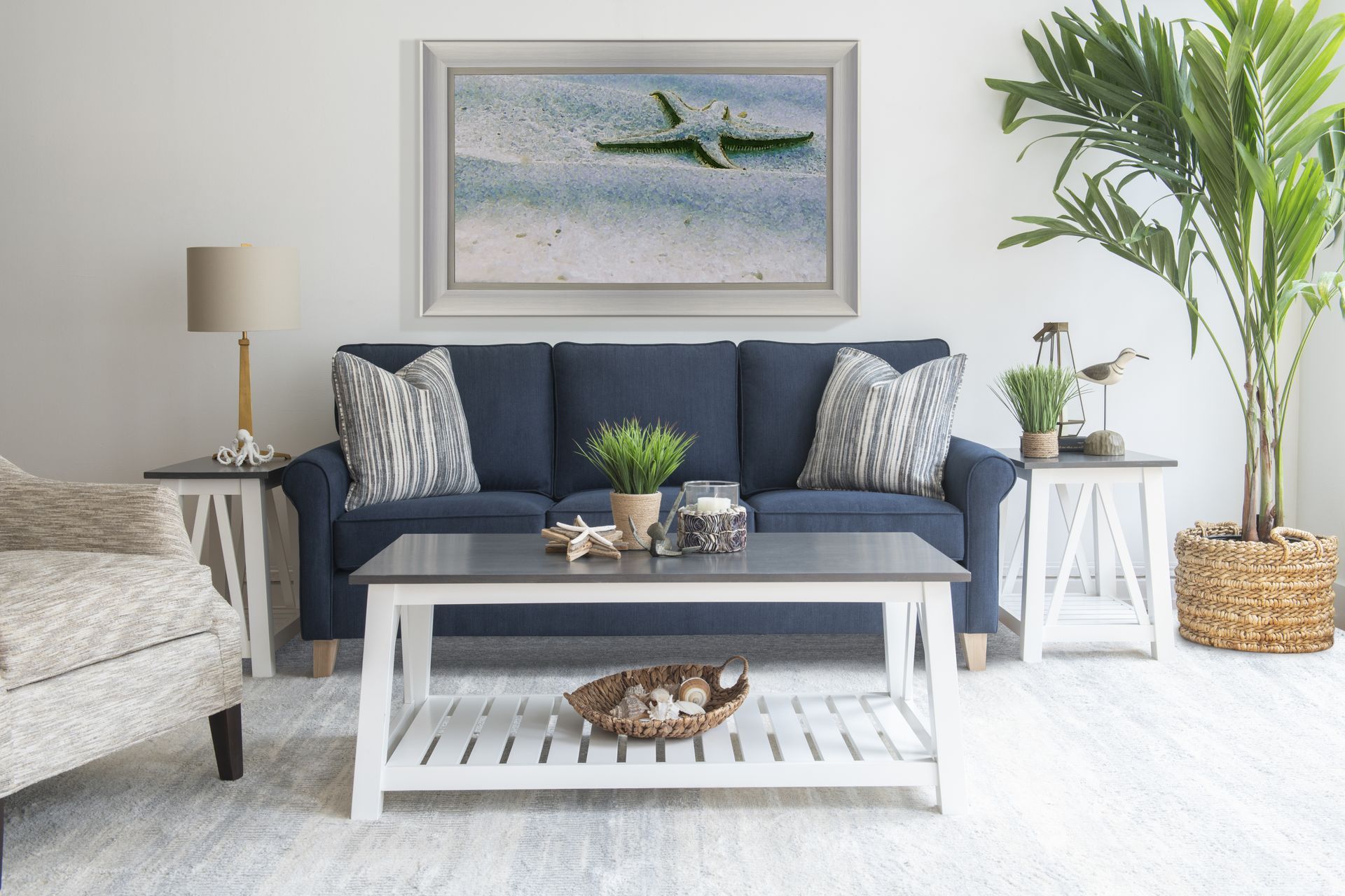 A coastal living room with a blue couch and a white coffee table