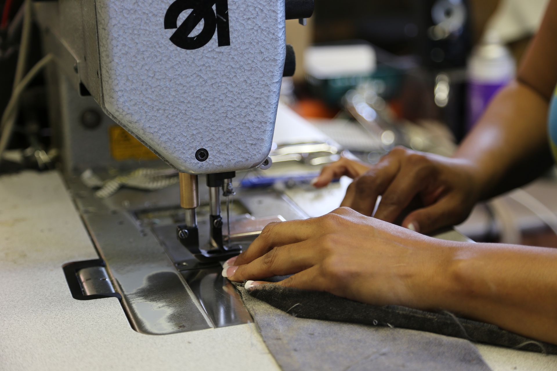A person is using a sewing machine with the number 12 on it