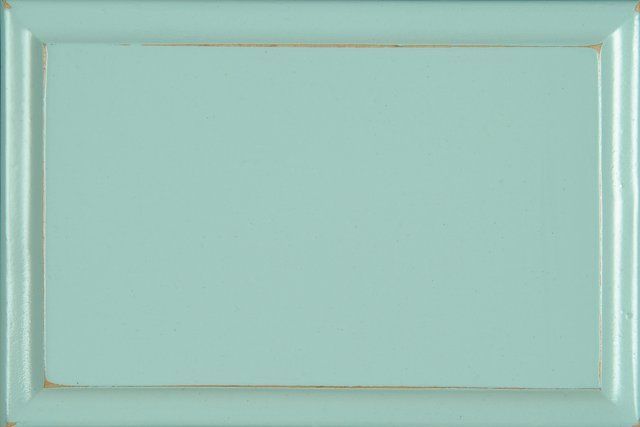 A rectangular cabinet door sample in light turquoise with a distressed edge.
