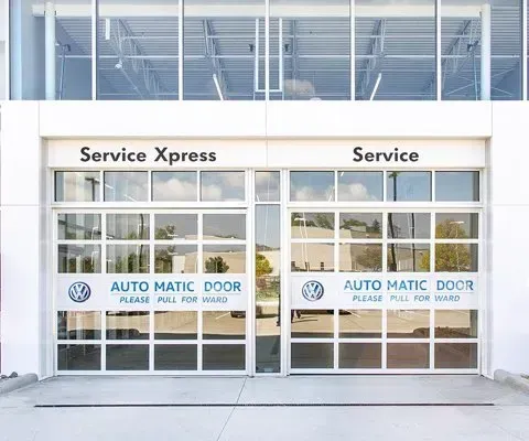 Two glass garage doors at a Volkswagen dealership: