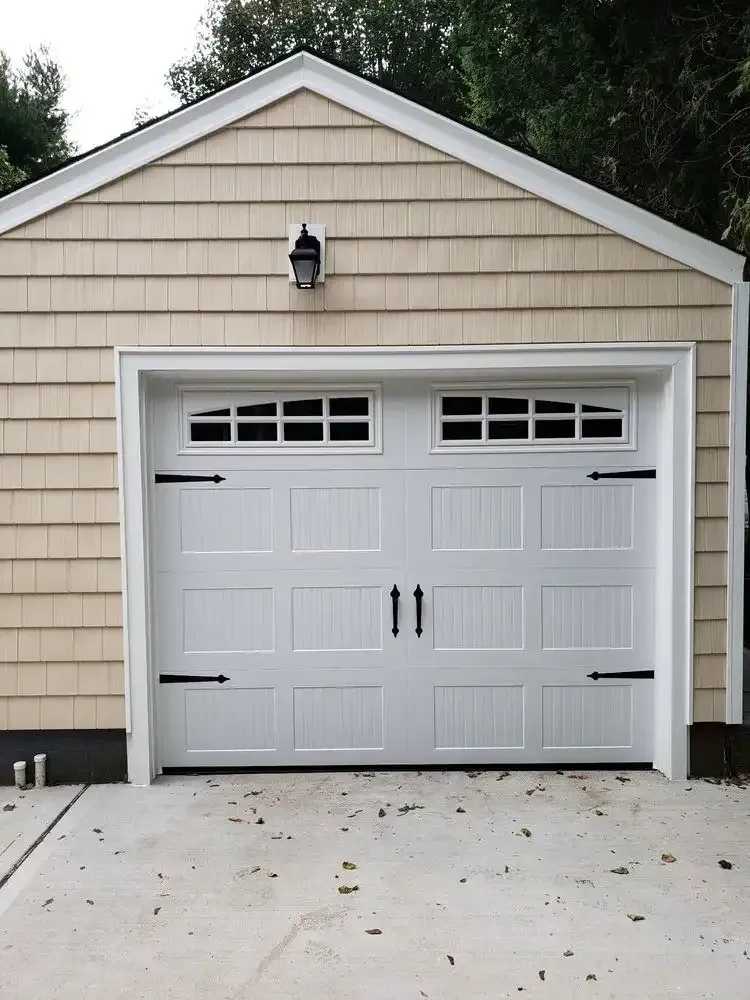 Three-car garage with basketball hoop in driveway; a van is parked on the left. Solar panels are on the roof.