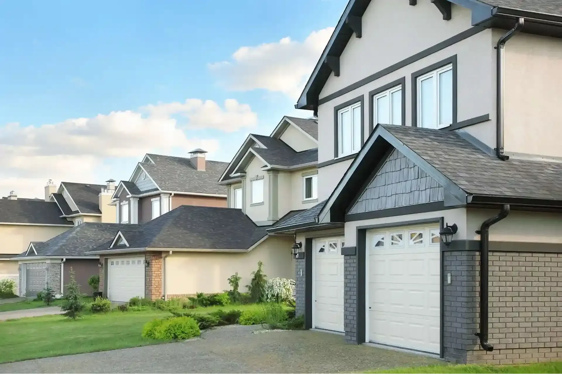 Open garage with vehicles inside; ceiling-mounted garage door opener and lights.
