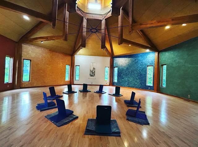A large room with a lot of chairs in a circle on the floor.