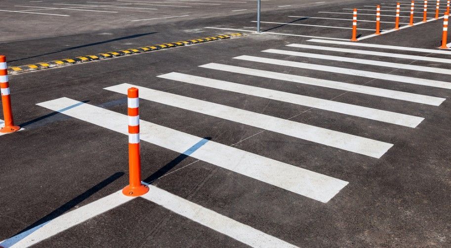 A Close Up of a Crosswalk With Orange Poles on the Side of the Road — Payton Civil Products in Wilsonton, QLD