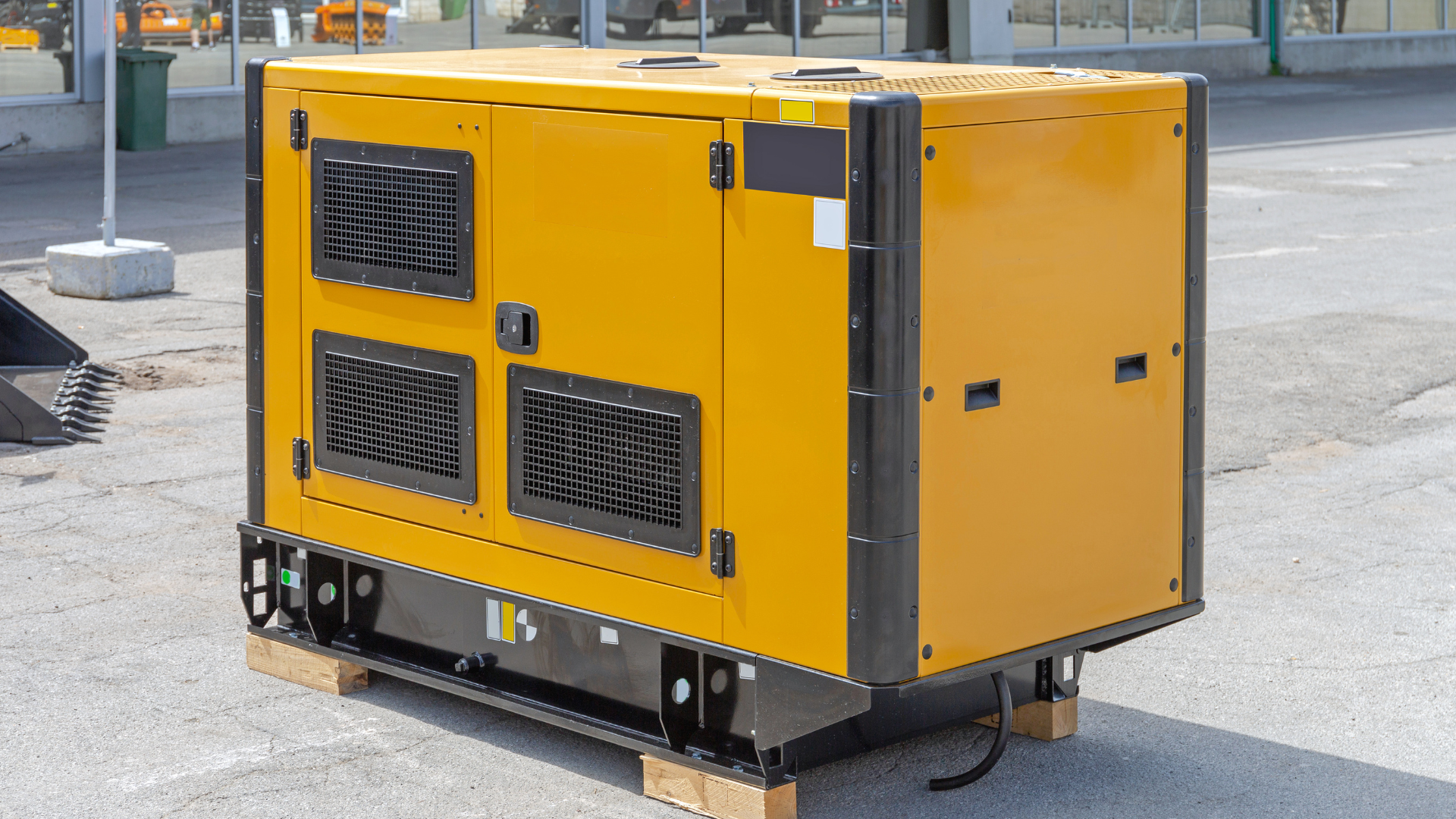 Yellow industrial generator on a pallet, outdoors.
