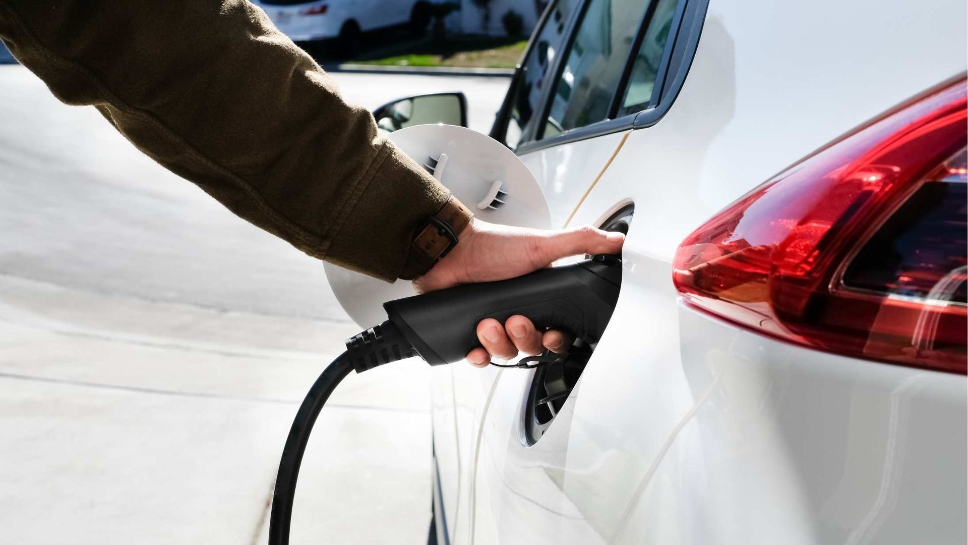 A person is charging an electric car with a charger.