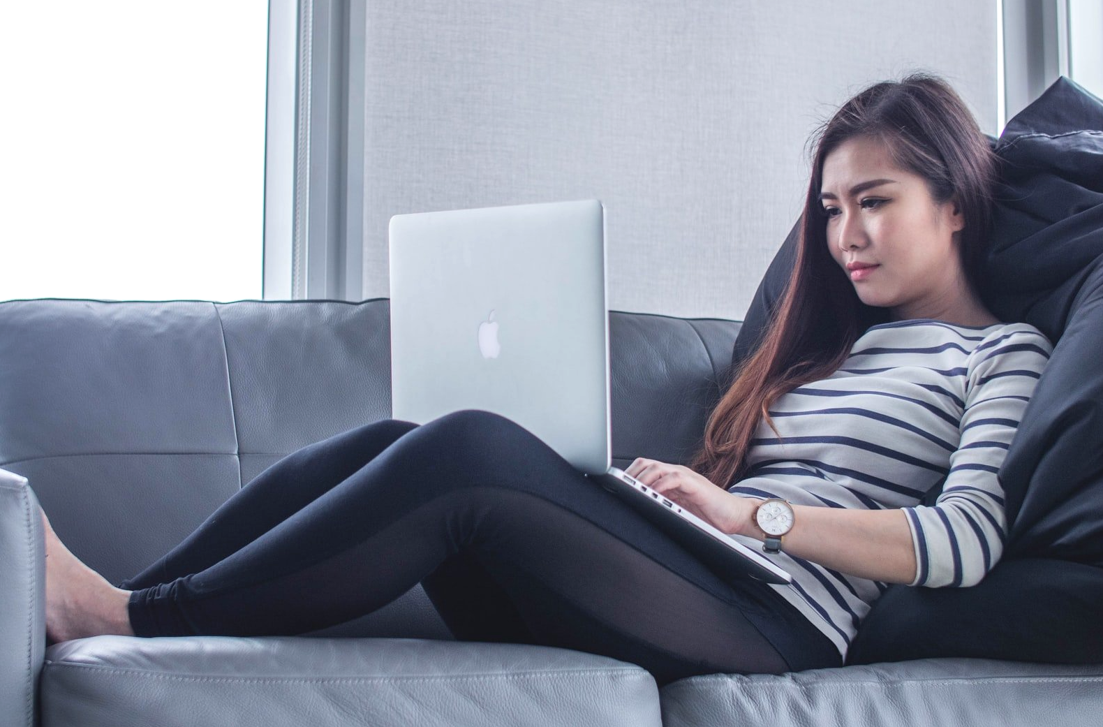 Sitting at home working on lap top. Image courtesy of: mimi-thian-BYGLQ32Wjx8-unsplash