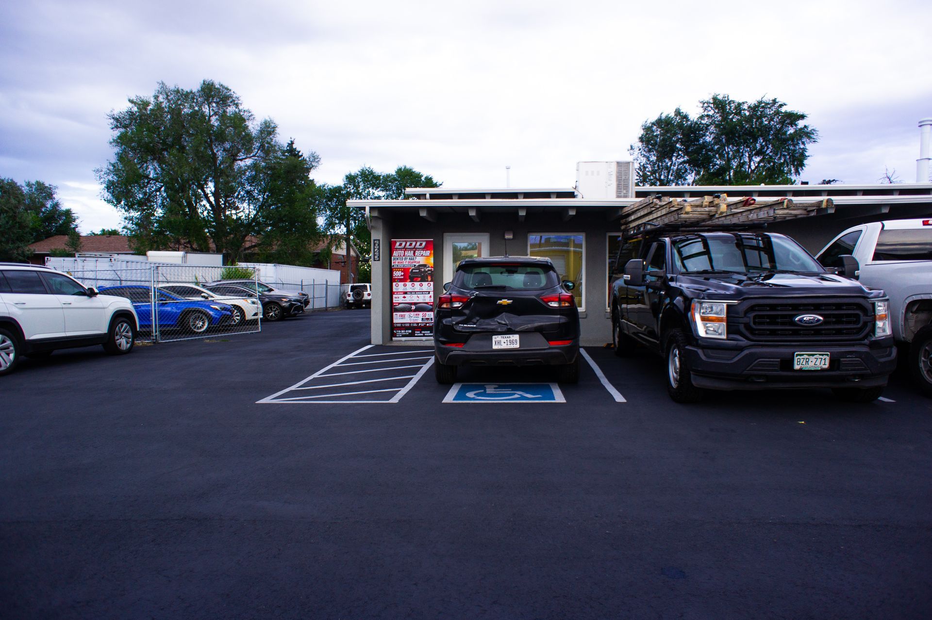 Black car roof with visible circular polish marks in a garage or workshop