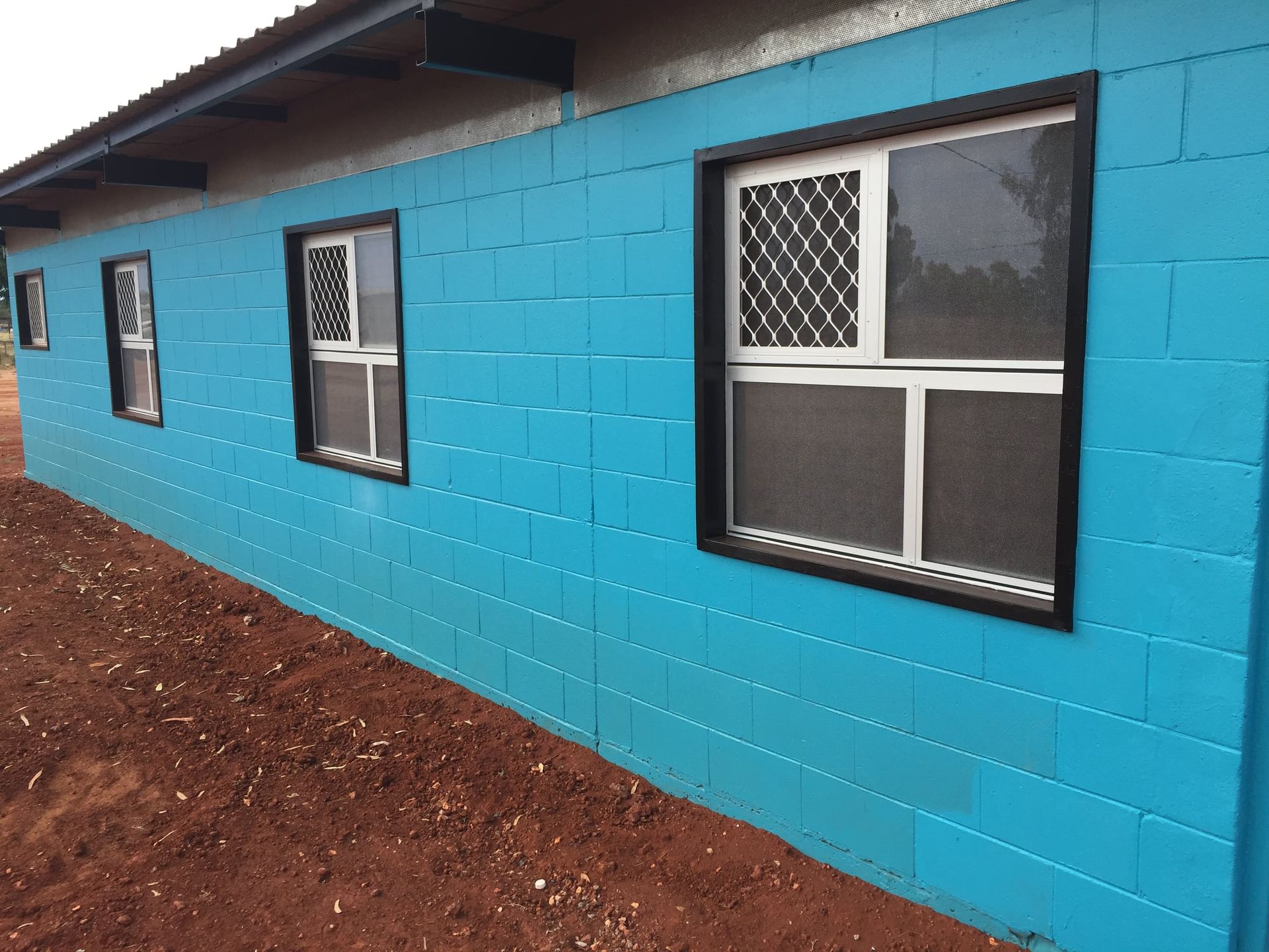 A Blue Brick Wall With A Row Of Windows — Bullant Building In  Ciccone, NT