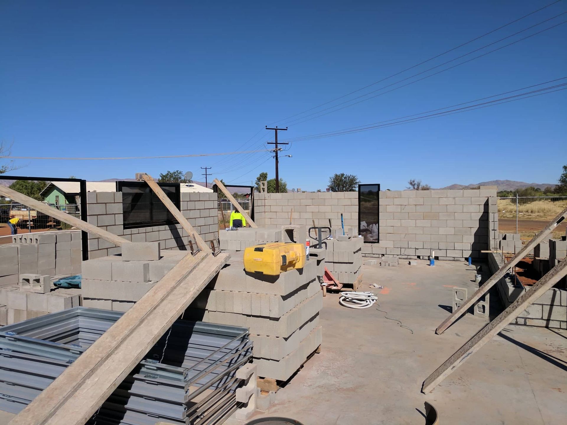 A construction site with a lot of bricks and a yellow machine — Bullant Building In  Ciccone, NT