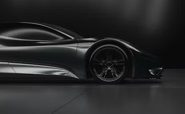 Black futuristic sports car in side profile on a dark studio background