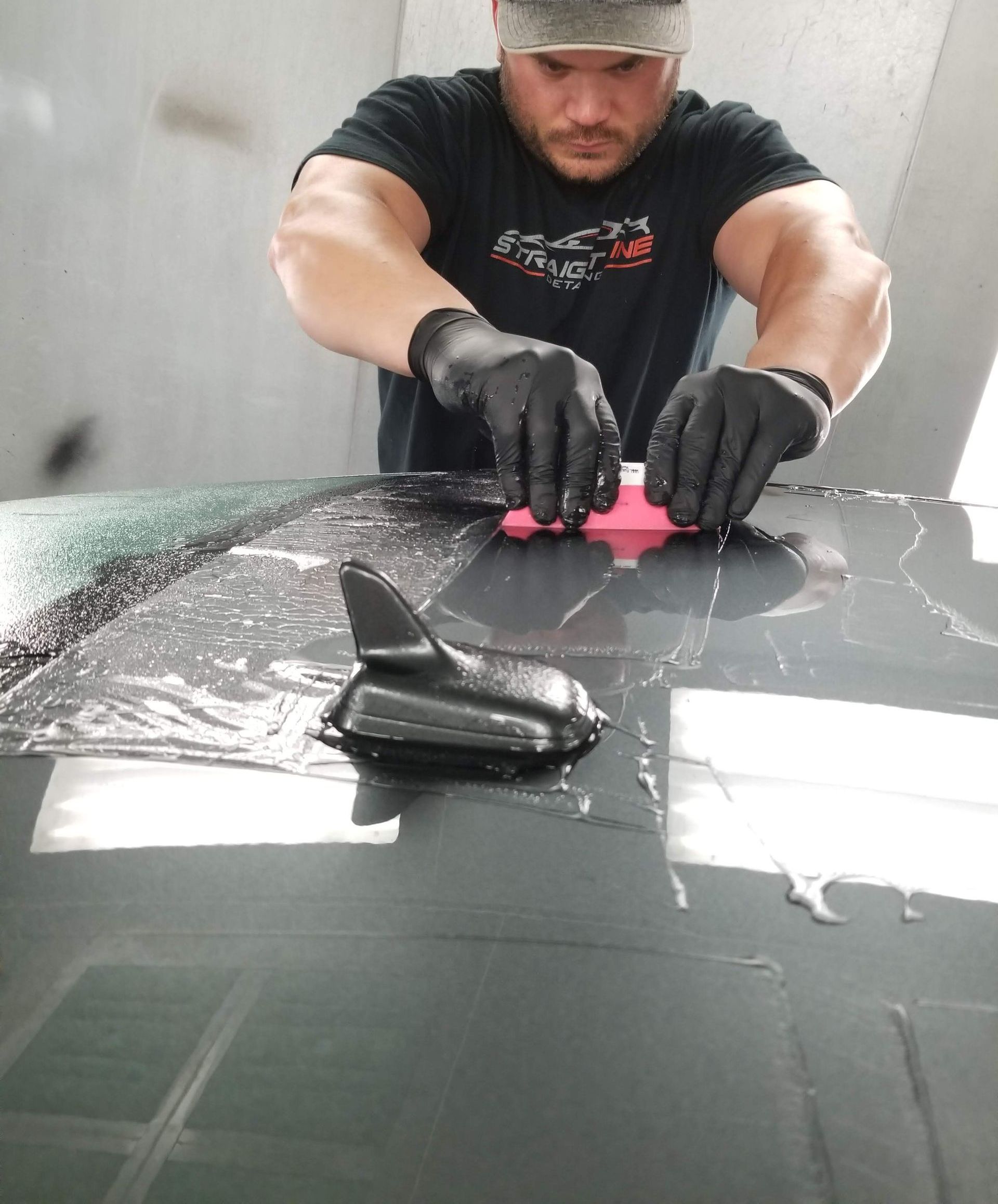 A person is cleaning a car with a blue sponge.
