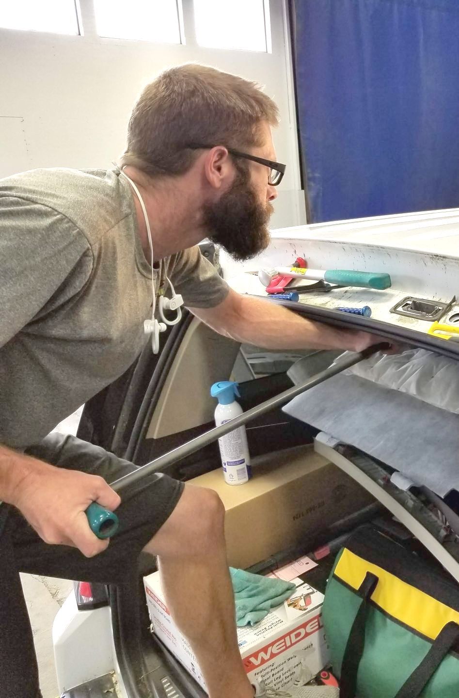 A person is applying tinted glass to a car window.