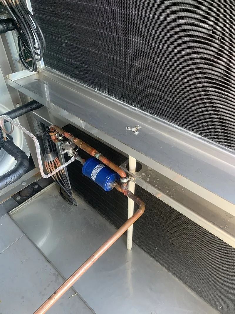 A Close Up of a Refrigerator With Copper Pipes Coming Out of It — Northside Air Conditioning Services In Aspley, QLD