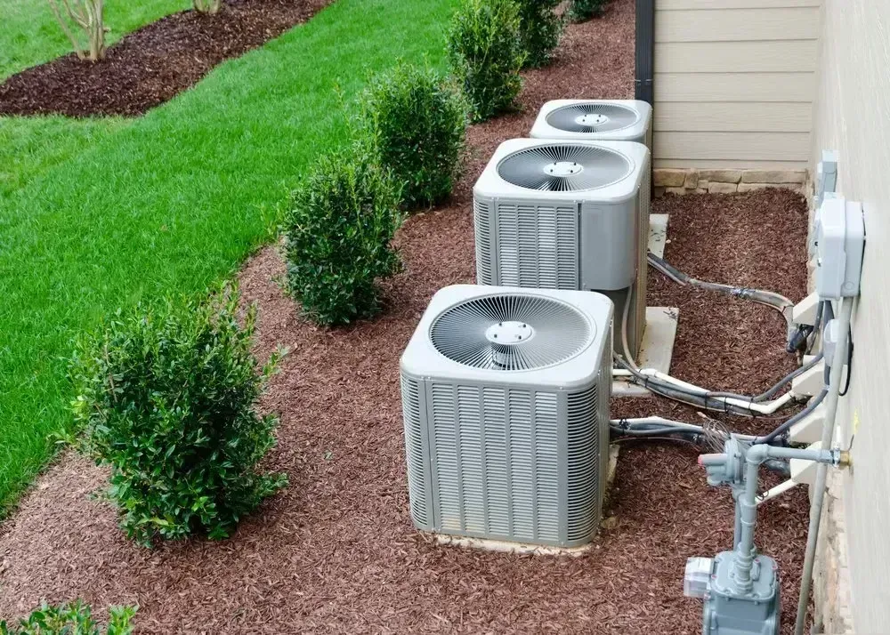 A Row of Air Conditioners Are Sitting on the Side of a House — Northside Air Conditioning Services In Chermside, QLD