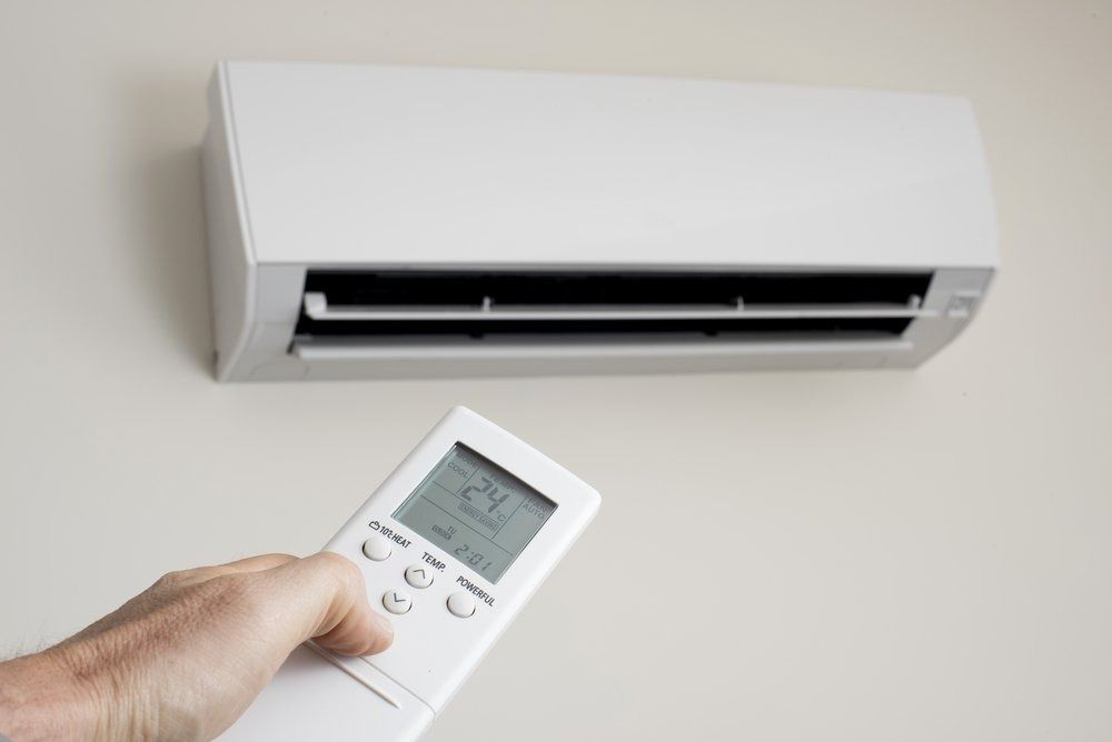 A Person is Holding a Remote Control of an Air Conditioner — Northside Air Conditioning Services In Bridgeman Downs, QLD