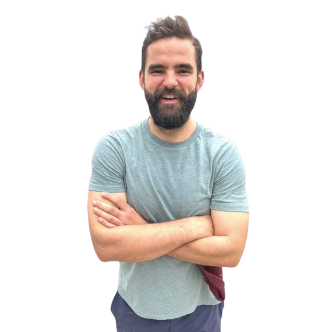 Eli Shipley in a light blue T-shirt with arms crossed against a white background