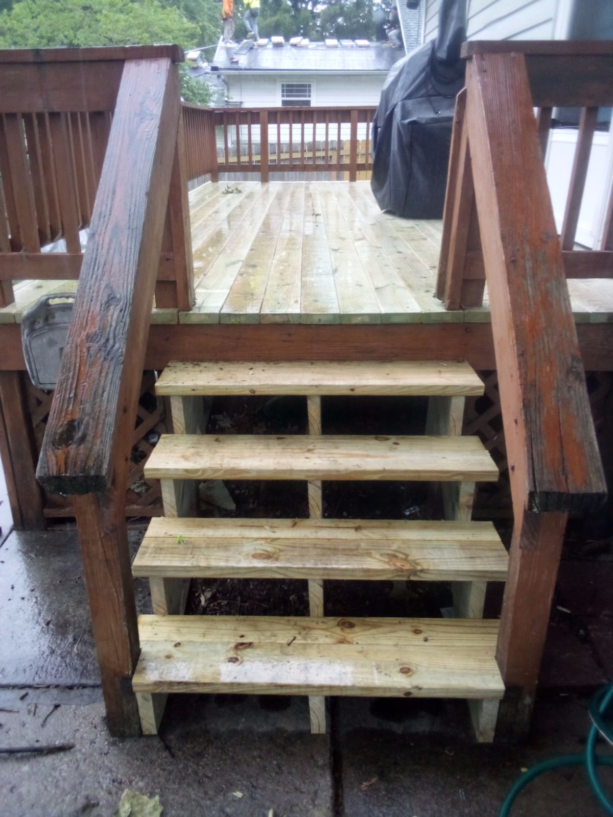 Newly installed light colored wood deck with a clear coating and a darker brown stained railing and stairs.