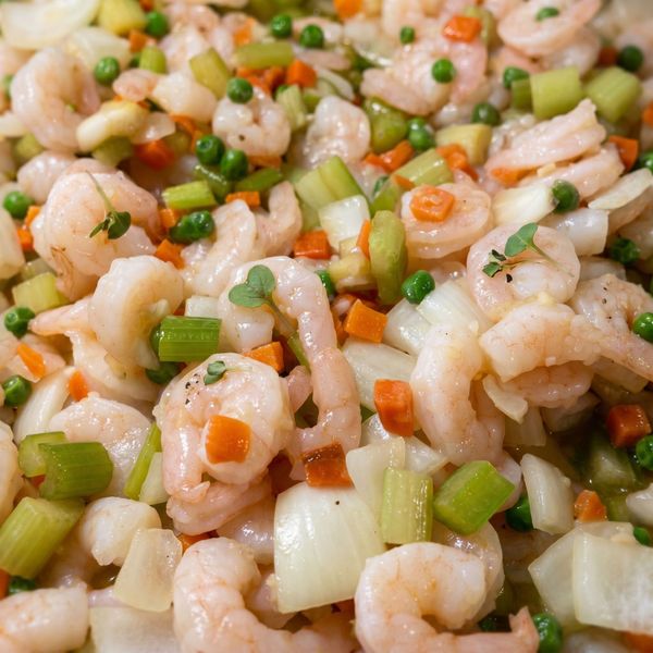 Close-up of shrimp salad with celery, onions, carrots, and herbs