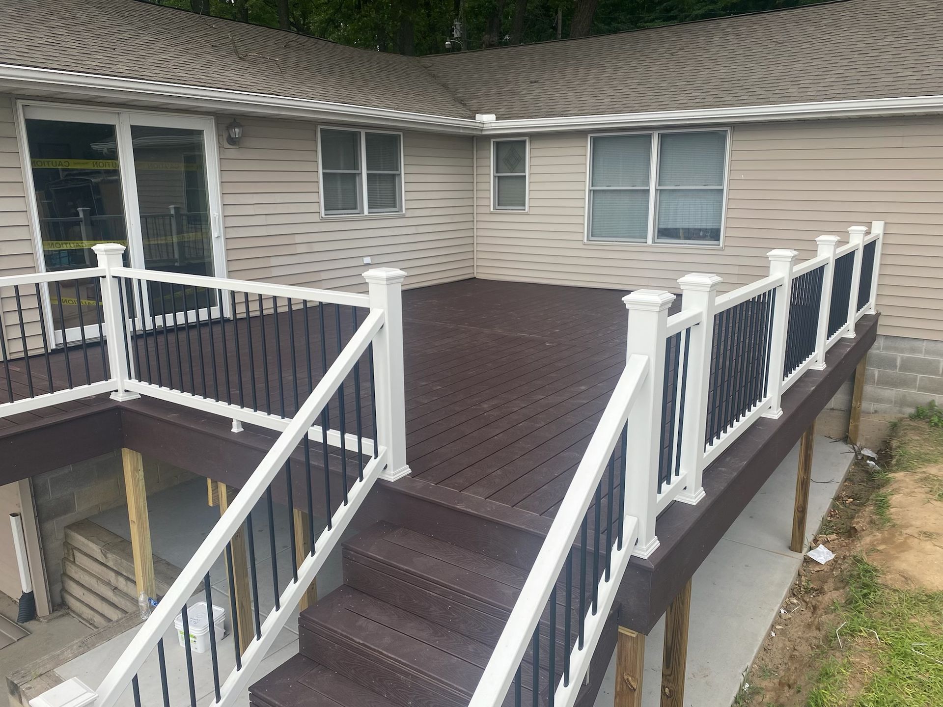 Wooden ramp and stairs with white railings leading to a beige house deck.