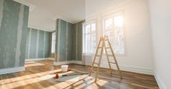 Room renovation: Before and after. Striped green wallpaper being removed, replaced by white paint. Ladder in front of window.