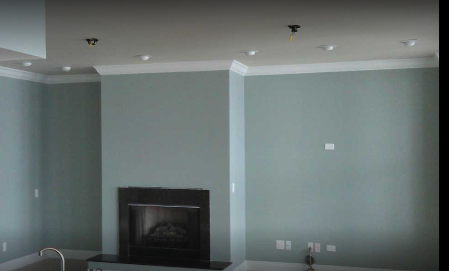 Empty living room with fireplace and light blue walls.