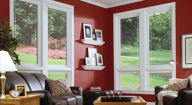 A living room with red walls and white windows