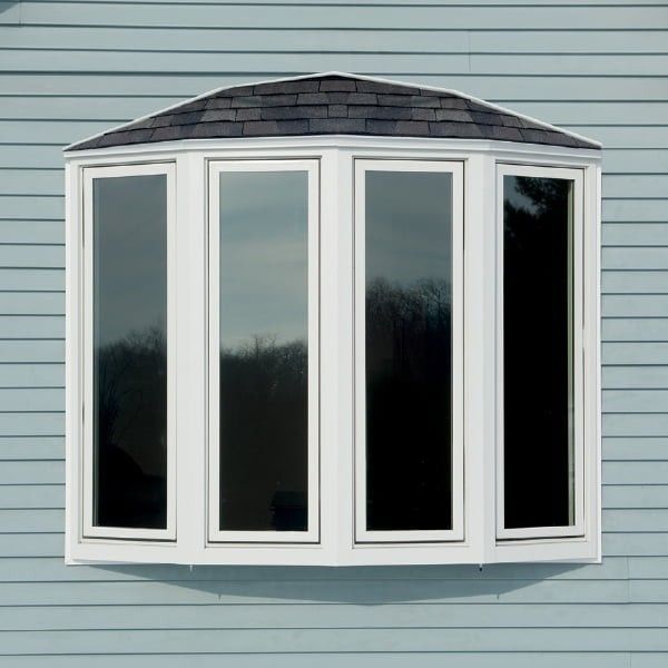 A white bay window with a roof on a blue house