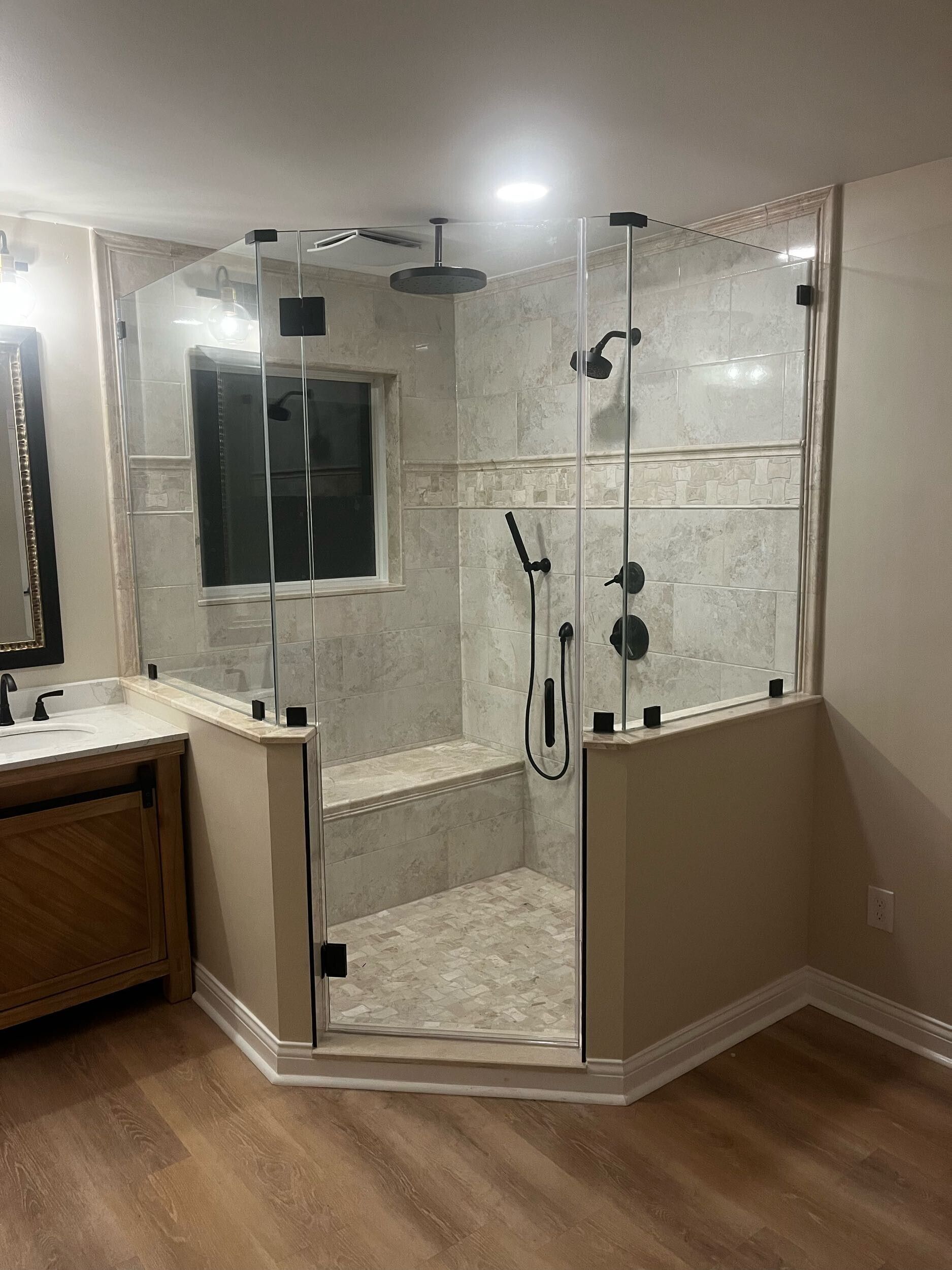 A bathroom with a walk in shower and a sink.