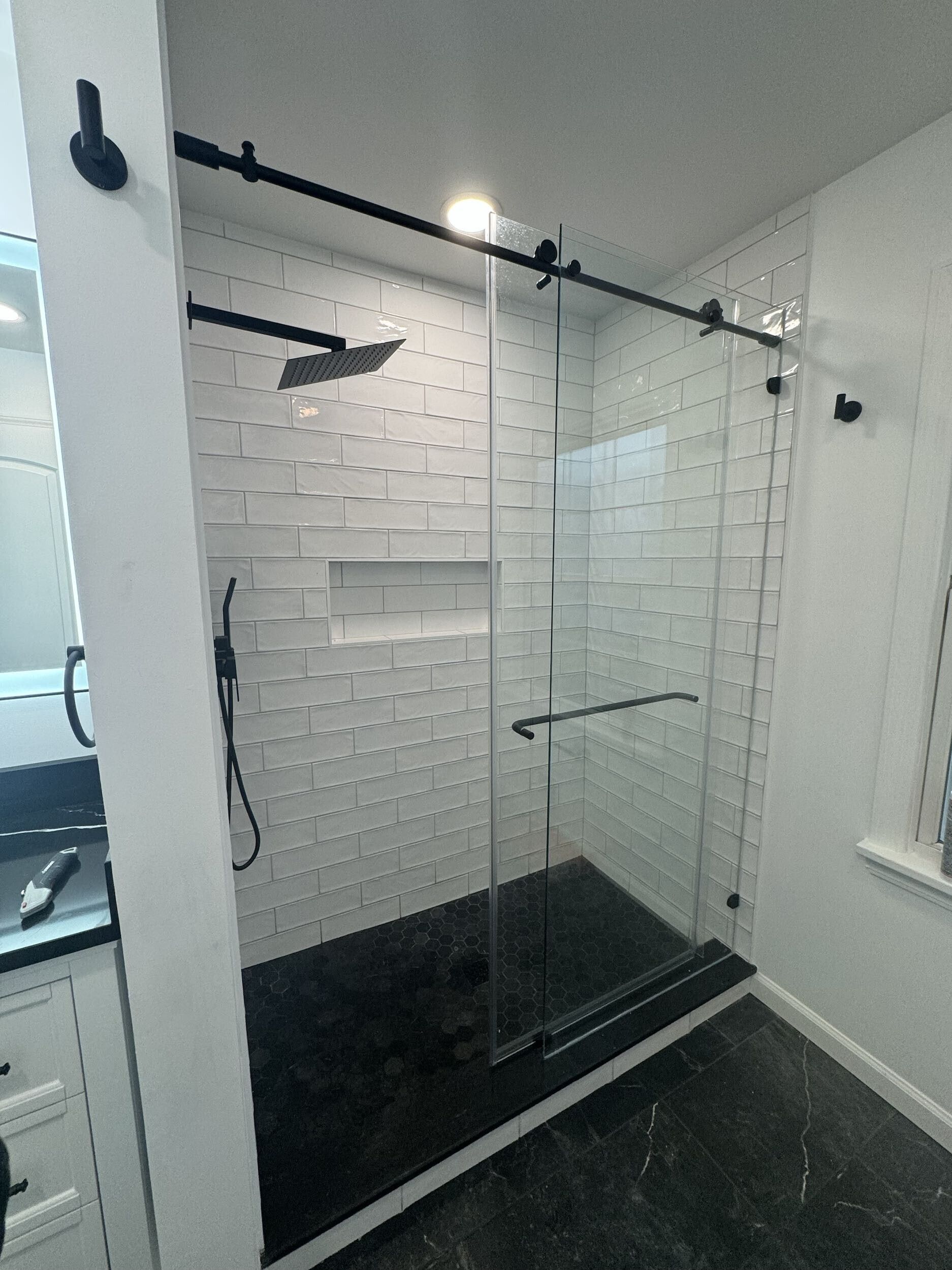 A bathroom with a sliding glass shower door and a shower head.