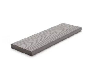 A gray wooden plank is sitting on a white surface.