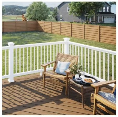 A wooden deck with a white railing and chairs