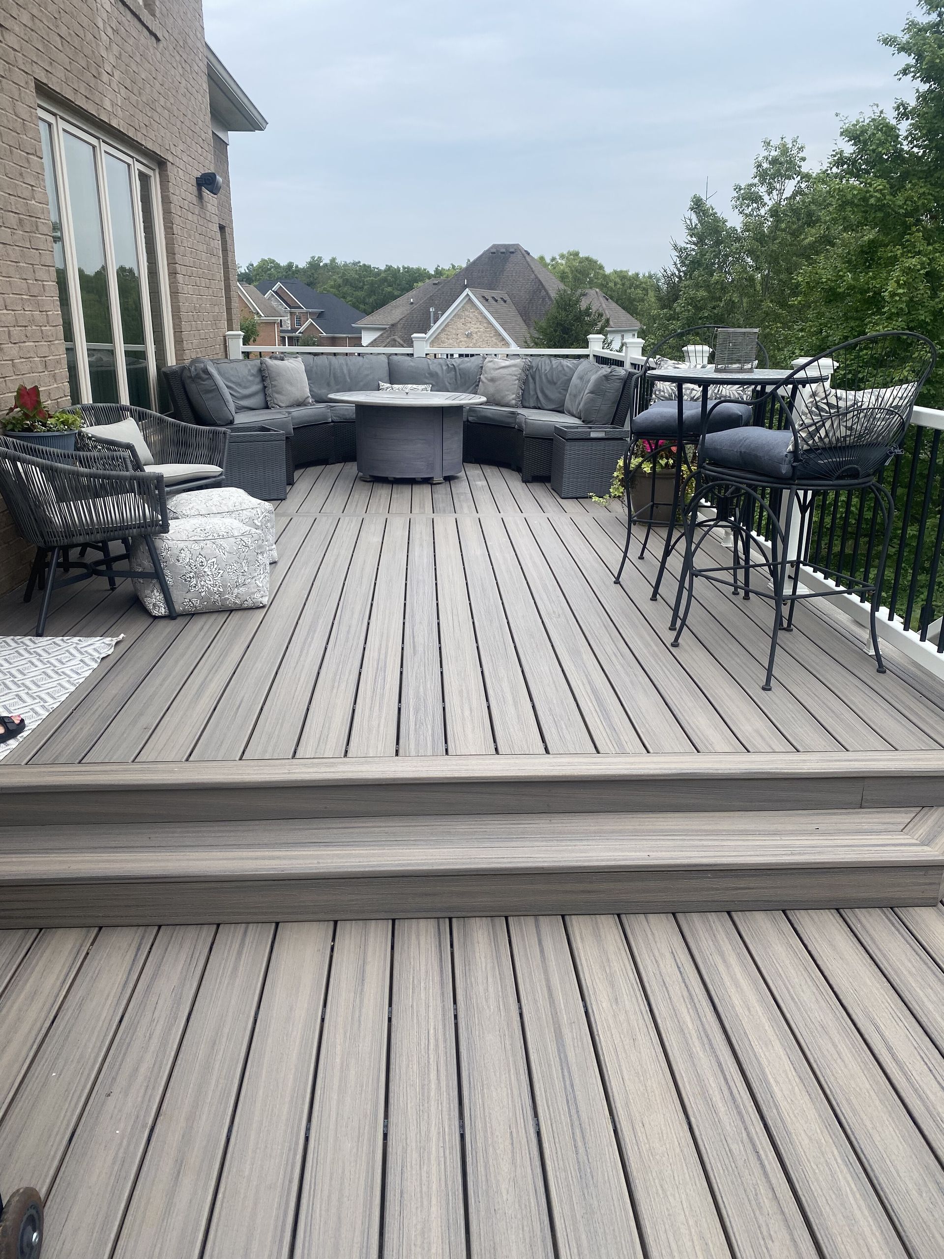 Outdoor patio with patterned paving, benches, and steps leading up to a landscaped garden area