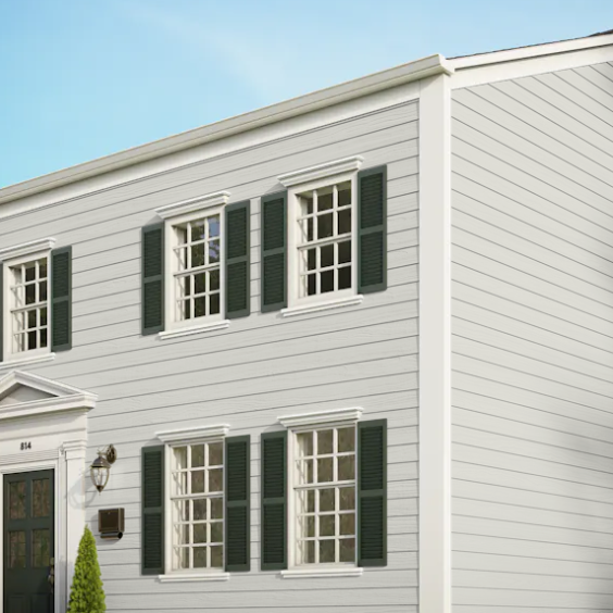 A white house with green shutters on the windows