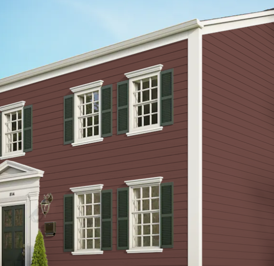 A brown house with white trim and green shutters