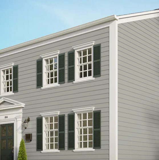 A grey house with white trim and green shutters