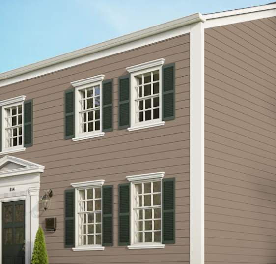 A brown house with white trim and green shutters