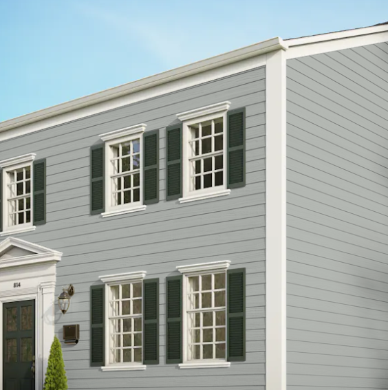 A grey house with white trim and green shutters